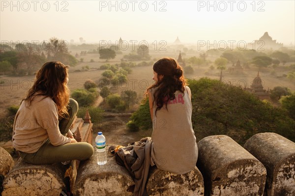 Women relaxing on stone wall