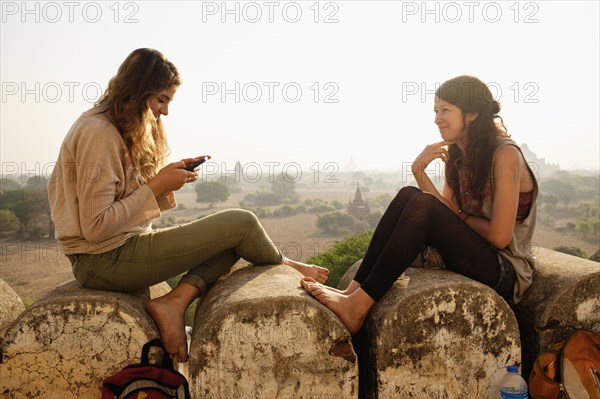 Women relaxing on stone wall