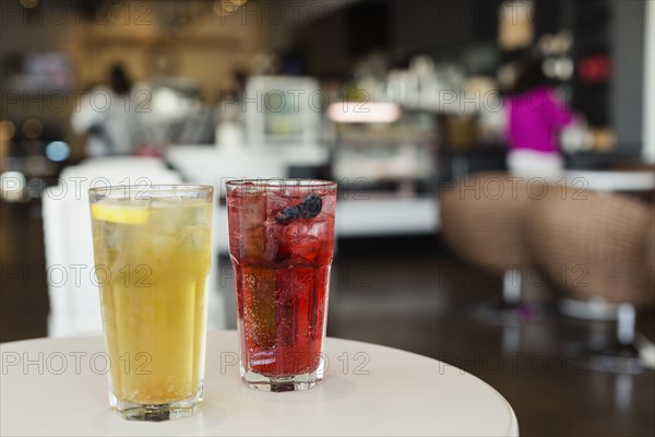 Mixed berry sparkling tea and green mint tea on table in coffee shop