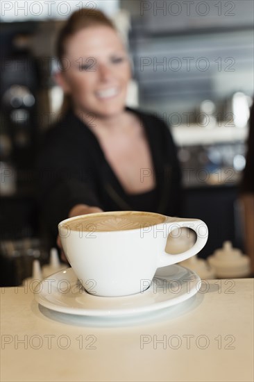 Coffee shop barista serving coffee