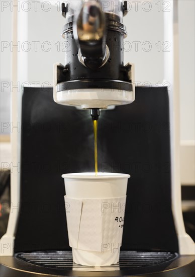 Coffee flowing from coffee machine in coffee shop