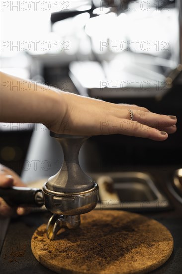 Coffee shop barista removing coffee grounds