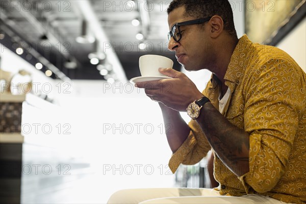 Young man drinking coffee in coffee shop