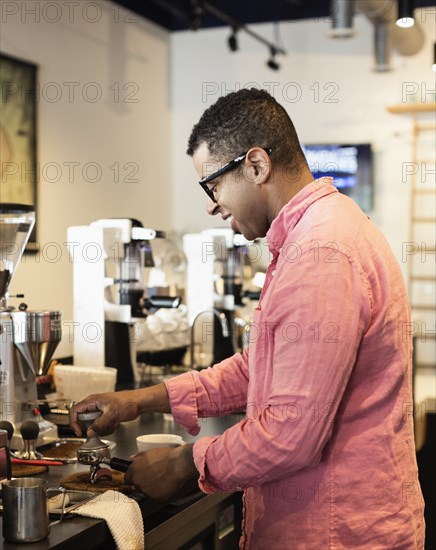 Coffee shop barista removing coffee grounds