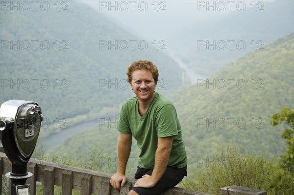 Portrait of mid adult man sitting on viewing platform