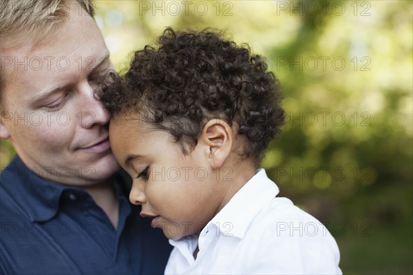 Cropped view of father and son face to face hugging