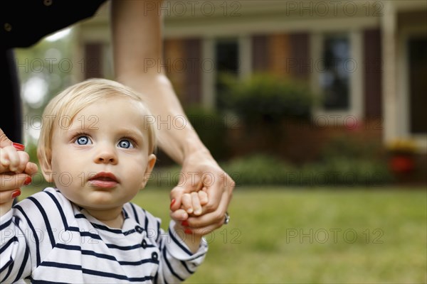 Mother holding baby girl's hands