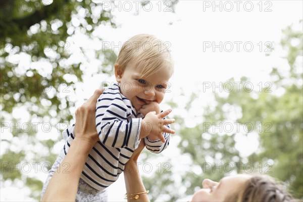 Mother holding baby girl in air