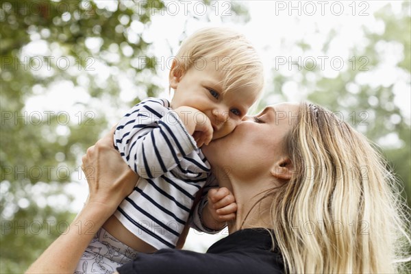 Mother kissing baby girl on cheek