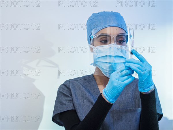 Nurse in face mask and shield preparing Covid-19 vaccination