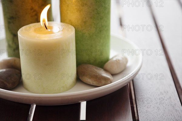 Close-up of candles and stones on plate