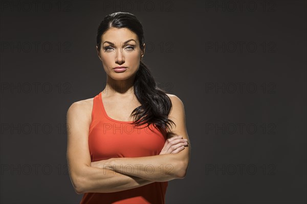 Studio portrait of athletic woman in red sleeveless top