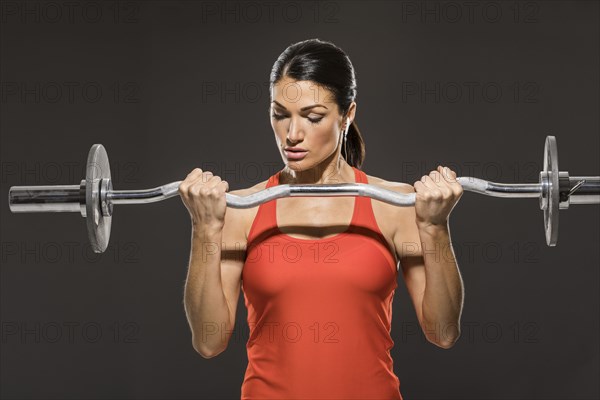 Athletic woman in red sleeveless top weight training