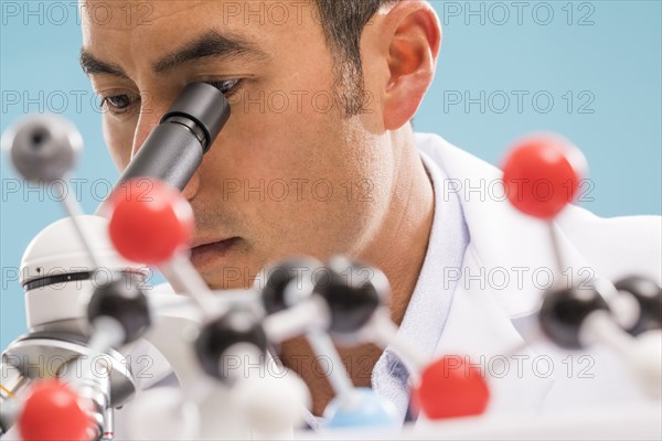 Close-up of scientist looking through microscope