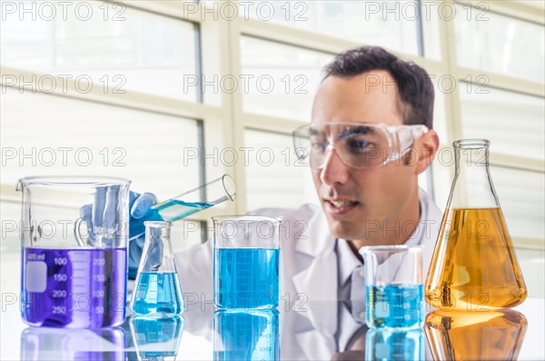 Scientist pouring blue liquid in laboratory