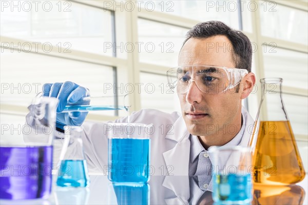 Scientist pouring blue liquid in laboratory