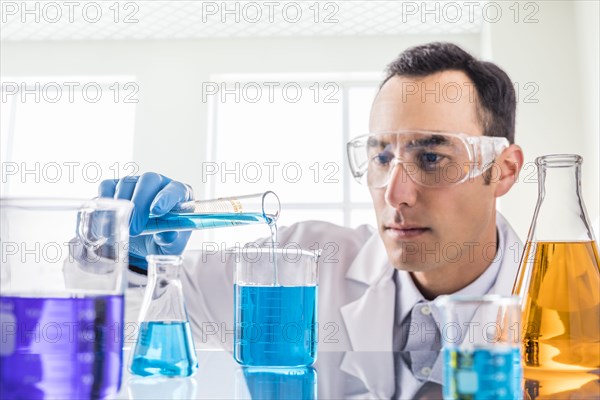 Scientist pouring blue liquid in laboratory