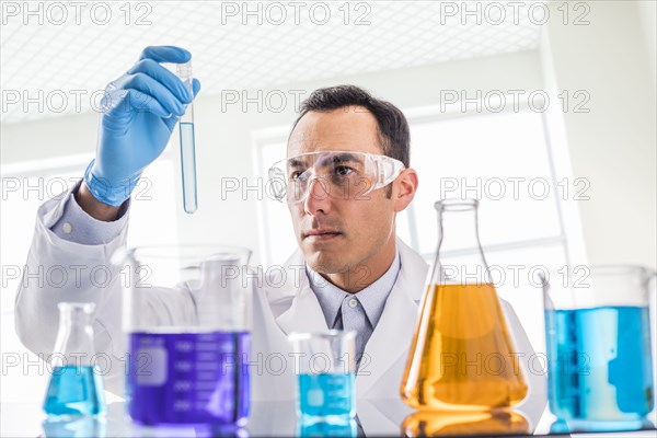 Scientist looking at blue liquid in laboratory