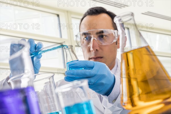 Scientist pouring blue liquid in laboratory