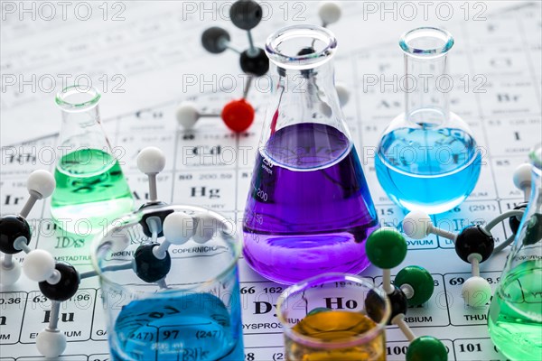 Molecular models and laboratory glassware with liquids on periodic table