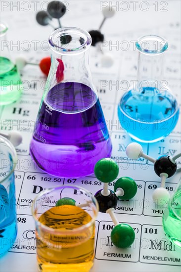 Molecular models and laboratory glassware with liquids on periodic table