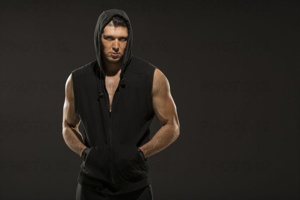 Portrait of muscular man in hooded vest