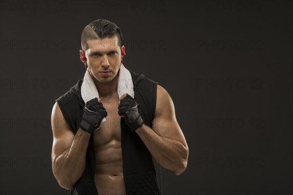 Portrait of muscular man wearing sports gloves