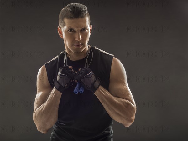 Portrait of muscular man wearing sports gloves