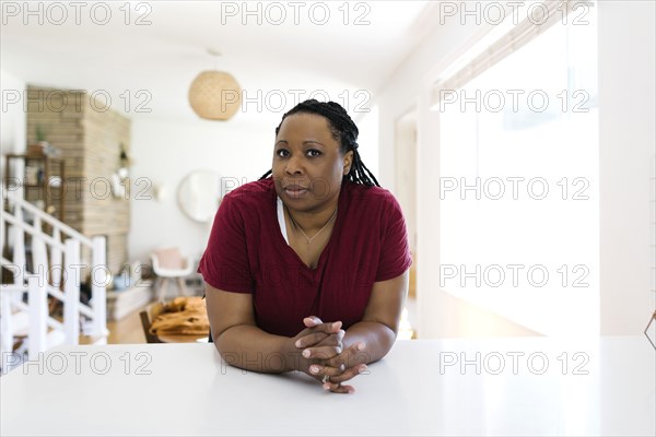 Portrait of woman leaning against kitchen counter