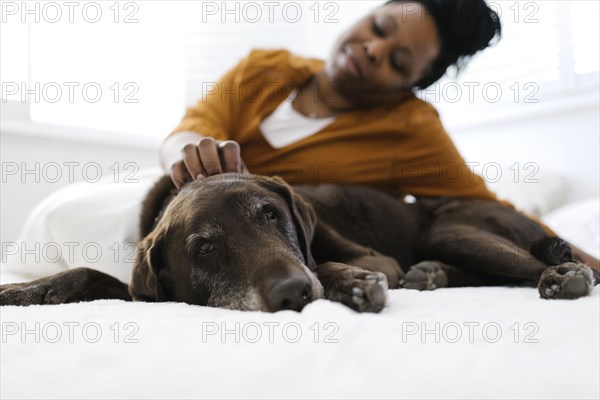 Woman petting dog at home