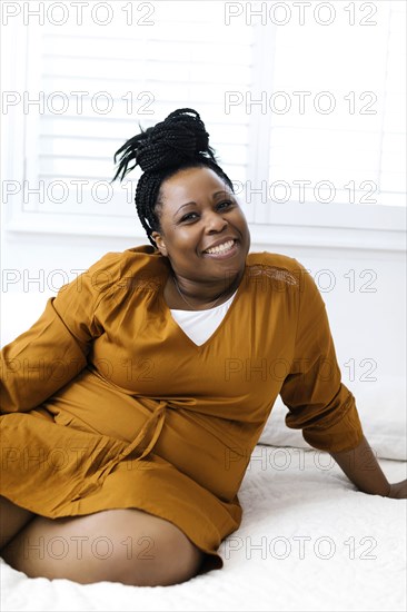 Smiling woman sitting on bed