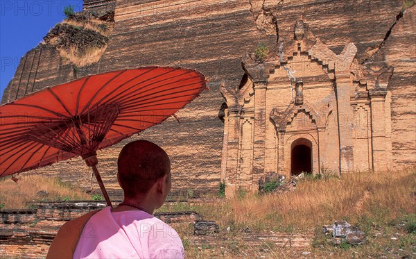 Buddhist nun in front of old Buddhist temple ruined by earthquake