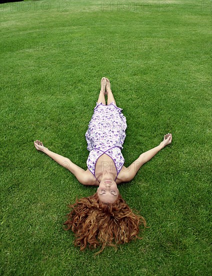 Young woman lying in lawn
