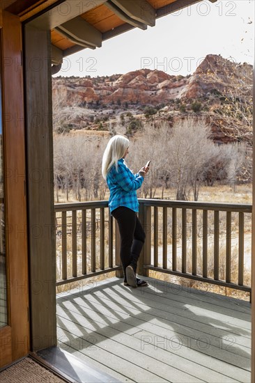 Woman on deck of home in canyon in Grand Staircase-Escalante National Monument