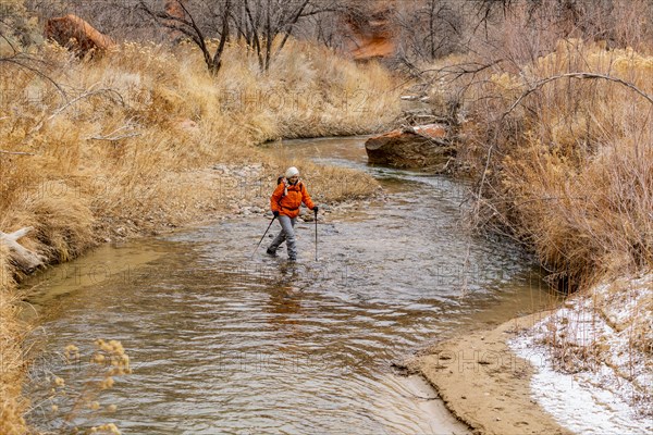 Woman wading across Escalante River in Grand Staircase-Escalante National Monument