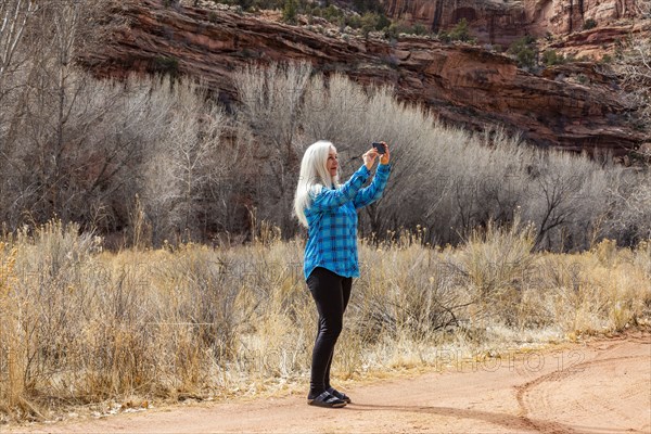 Woman taking pictures while hiking in Grand Staircase-Escalante National Monument