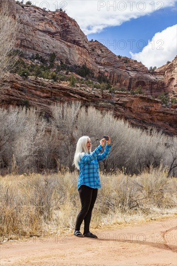 Woman taking pictures while hiking in Grand Staircase-Escalante National Monument