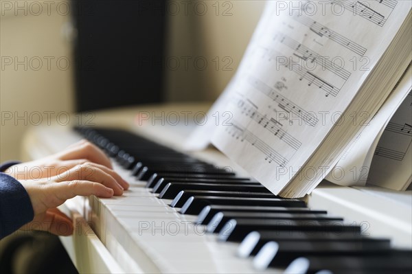 Hands of boy (6-7) playing piano