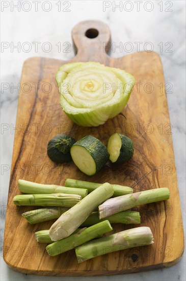 Vegetable scraps ready for compost on wooden cutting board