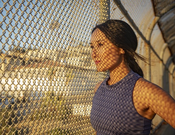 Athlete woman resting at fence