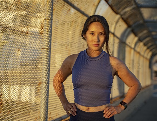 Portrait of athlete woman at fence