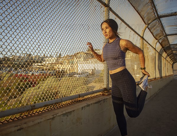 Athlete woman stretching at fence