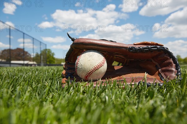 Baseball glove and ball on grass