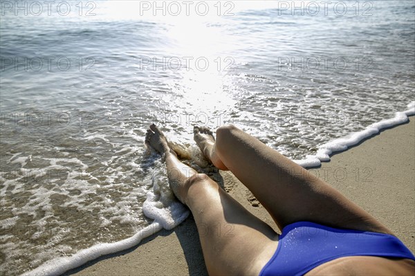 Woman in bikini lying on beach