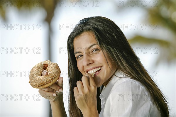 Portrait of smiling woman eating donut