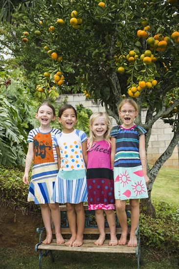 Smiling girls standing on bench