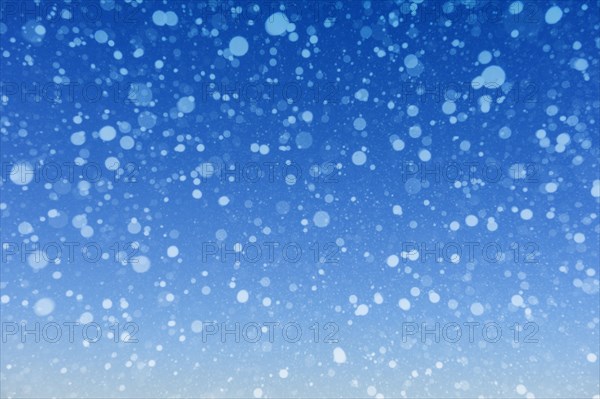 Falling snow against blue background