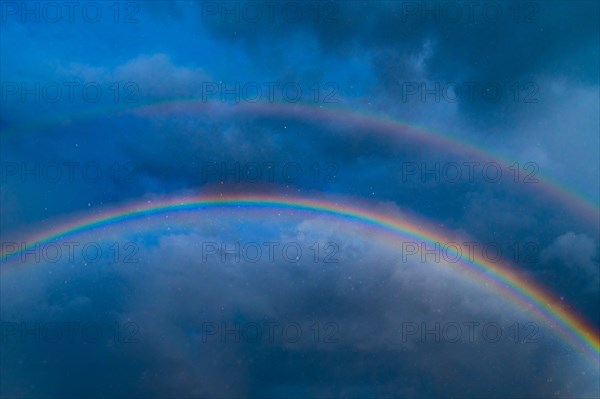 Double rainbow against stormy sky