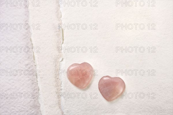 Glass hearts on white paper