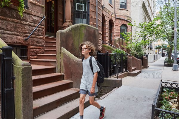 USA, New York, New York City, Boy walking in residential district